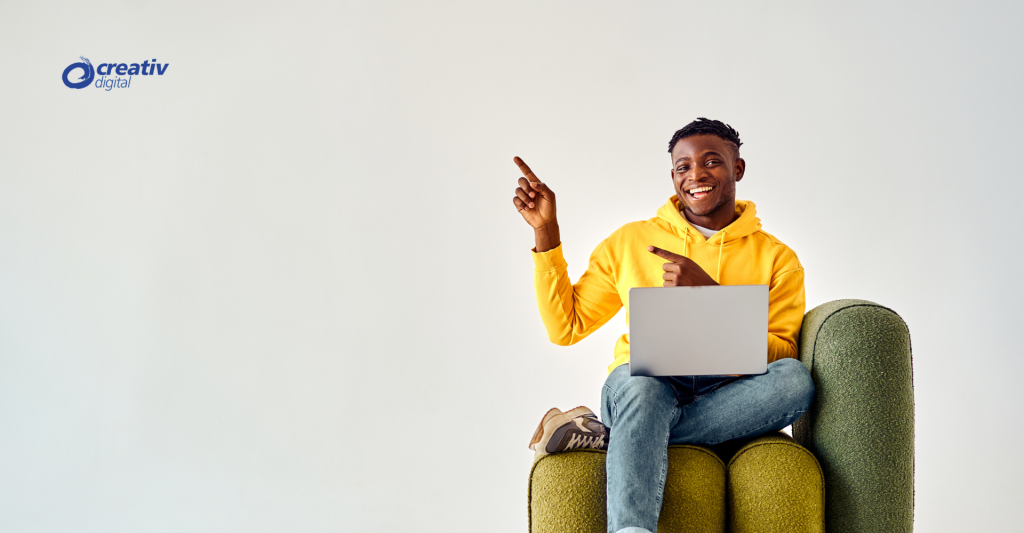 Sitting person pointing to the right with laptop